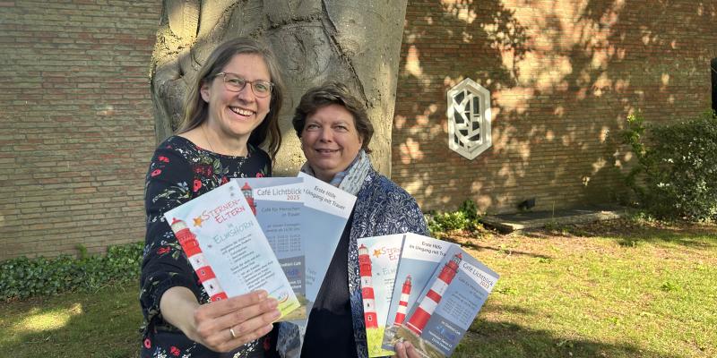 Corinna Schmucker und Miriam Kunkel zeigen die aktuellen Faltblätter der Trauerlandschaften.